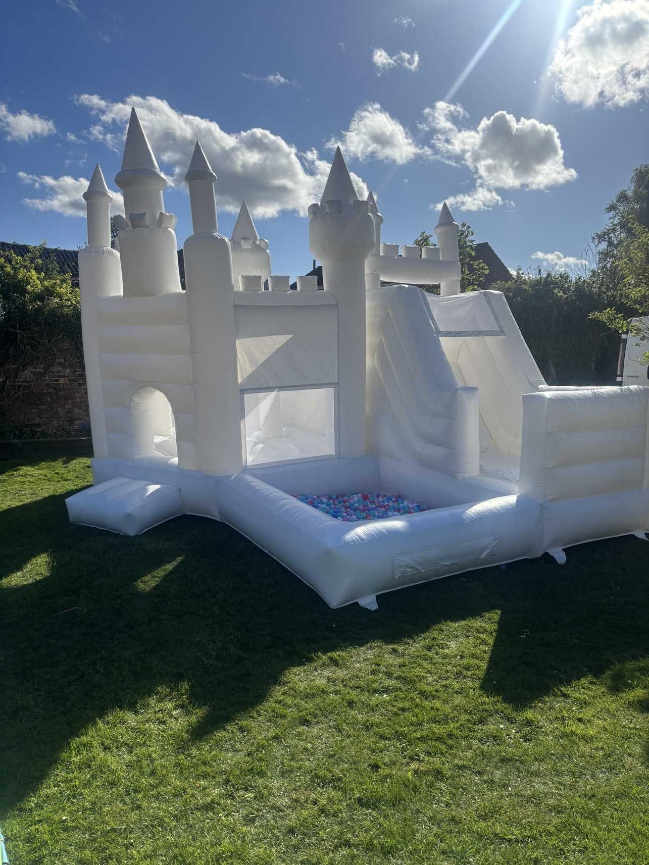 white bouncy castle with slide and ball pit