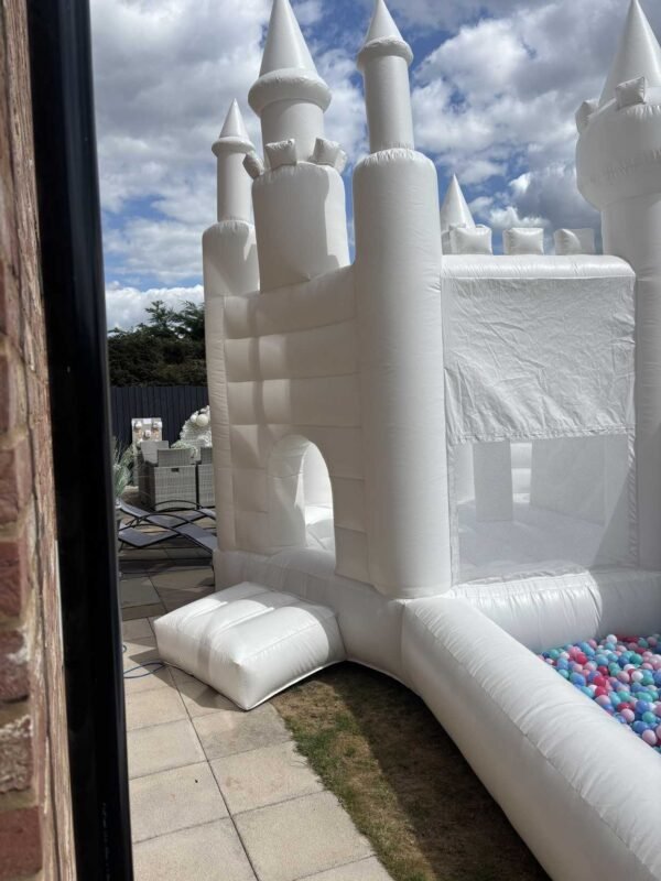white bouncy castle with slide and ball pit