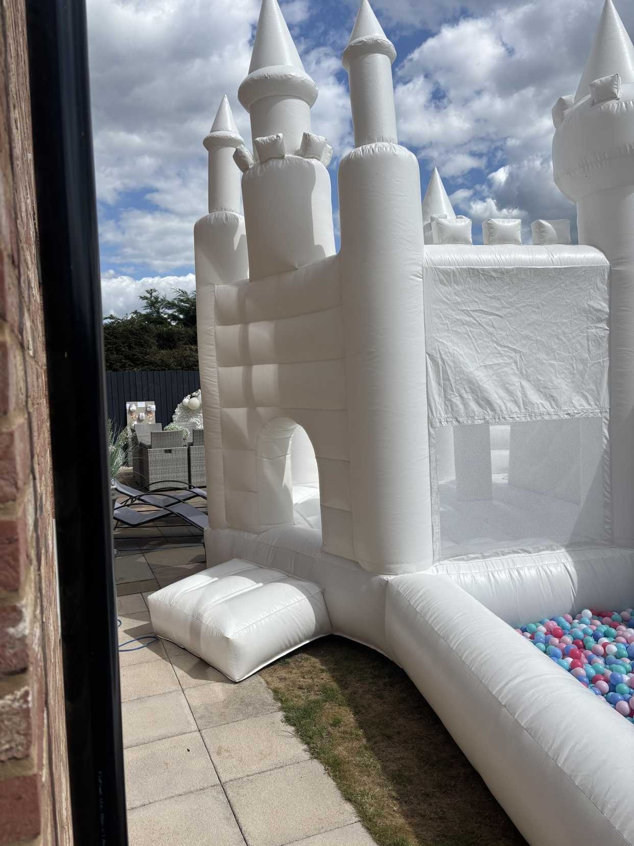 white bouncy castle with slide and ball pit