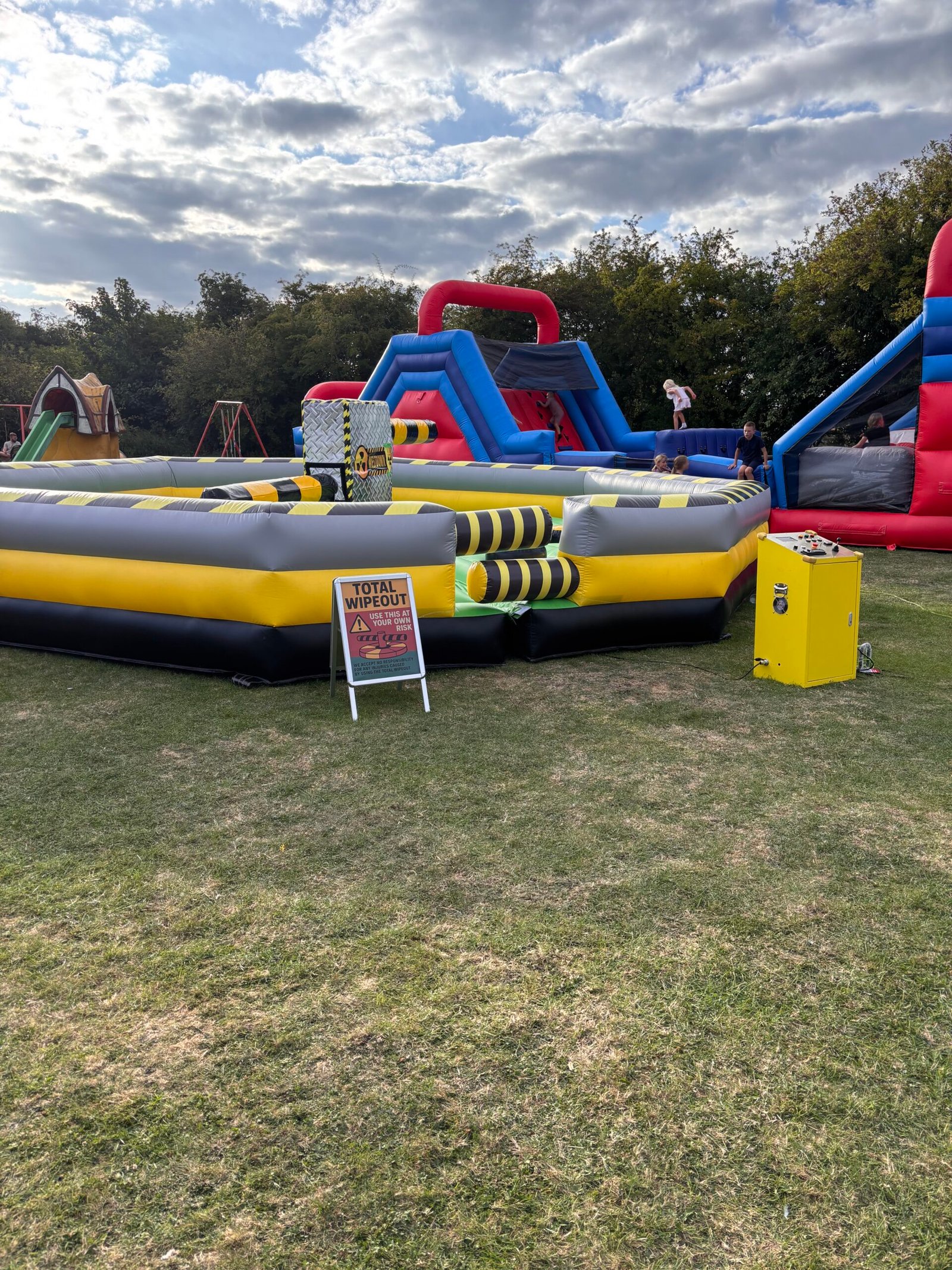 Total Wipeout inflatable at outdoor festival Grimsby with other bouncy castles
