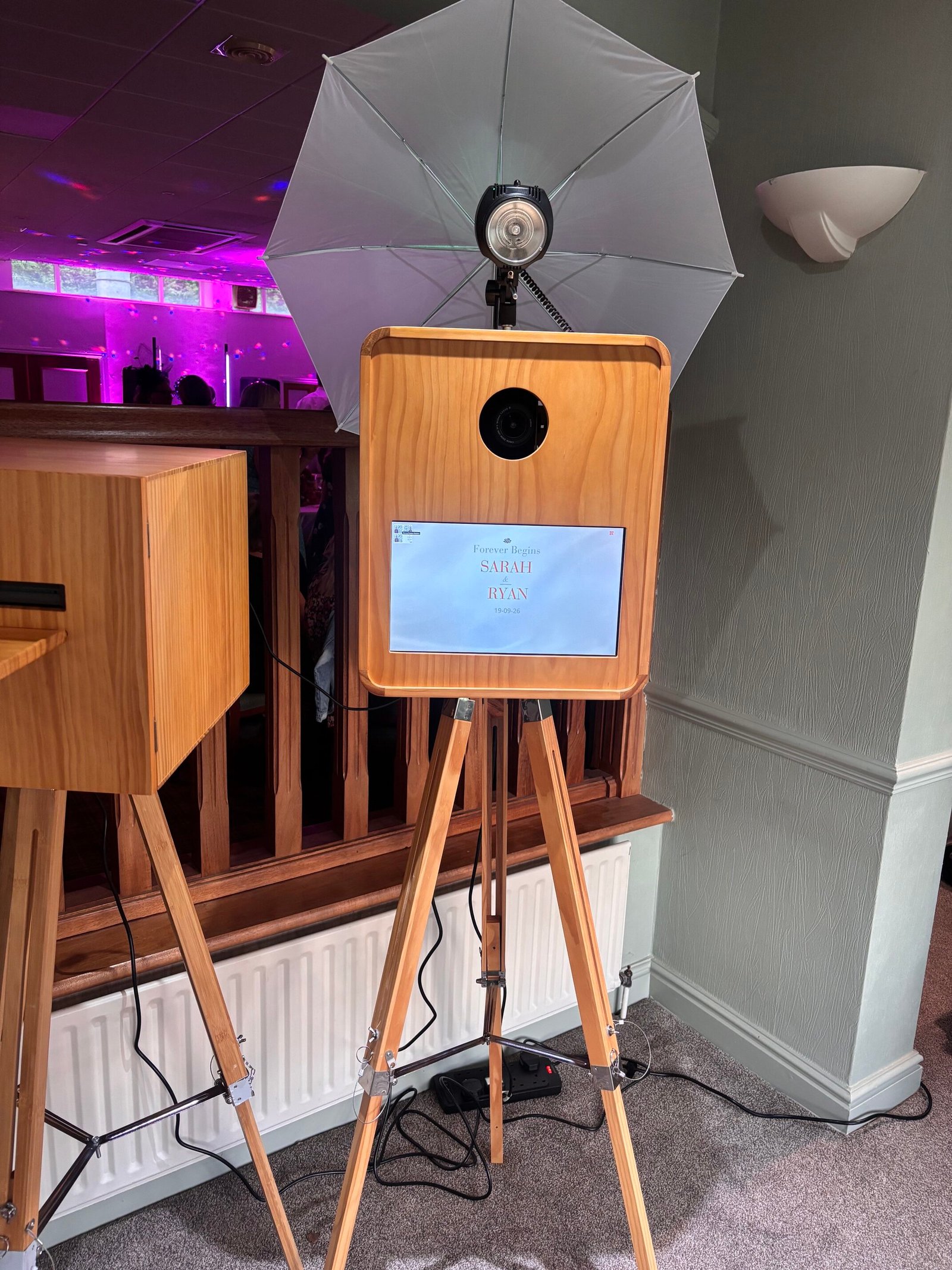 Wooden retro photo booth with DSLR camera, touchscreen and umbrella flash at a wedding